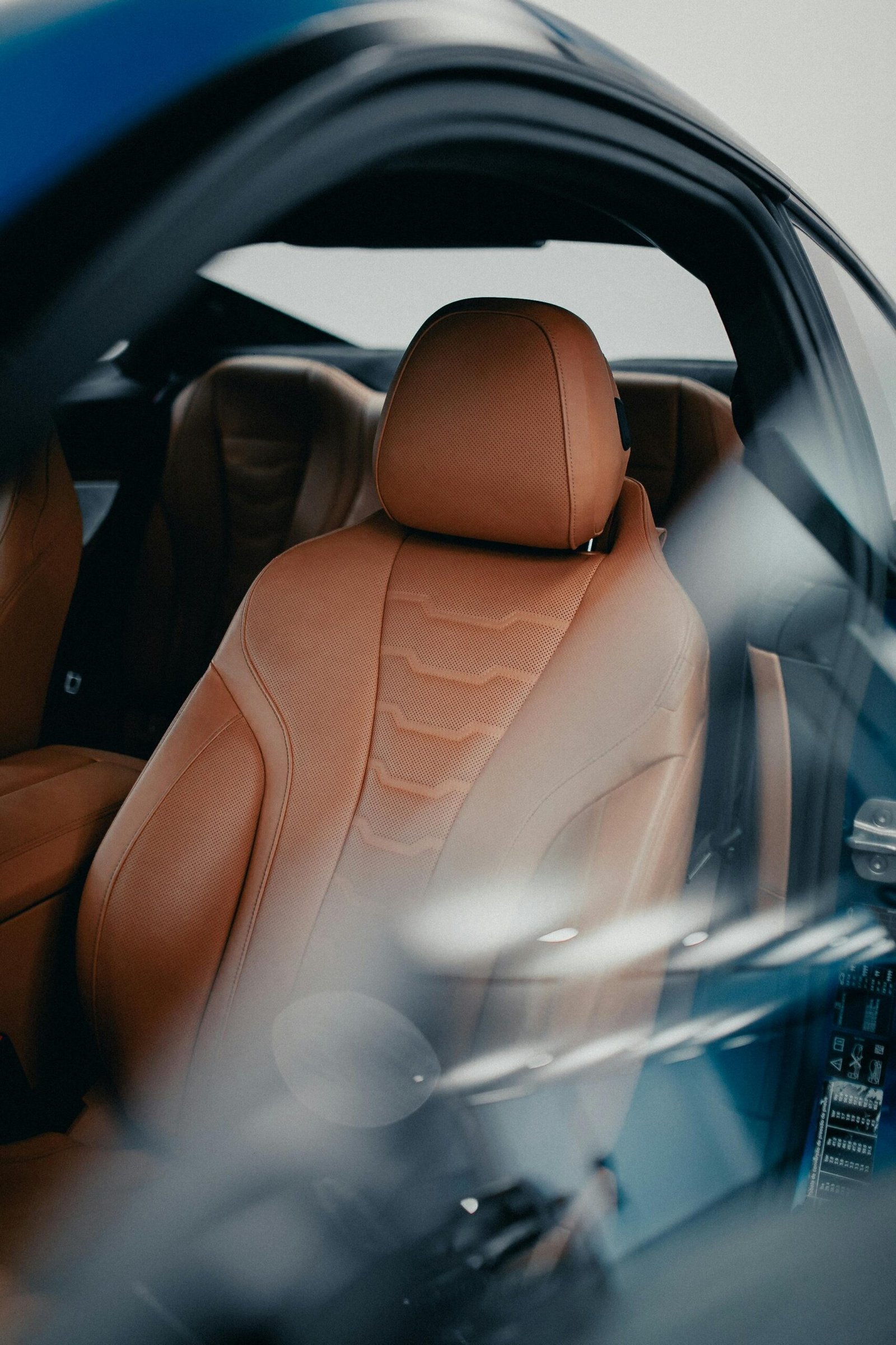 Close-up of a luxurious brown leather car seat inside a modern vehicle, showcasing premium interior design.